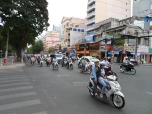 A typical Saigon street crossing. You can literally cross the street with your eyes closed. The bikes will just flow around you.